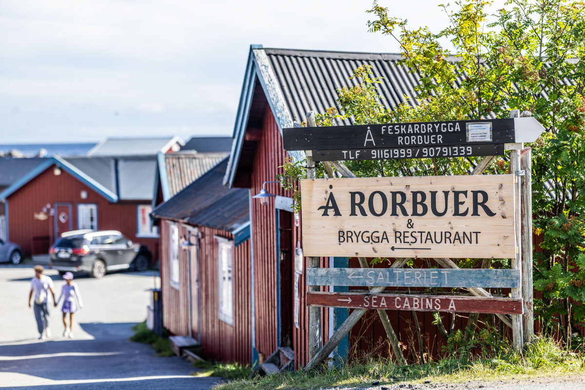 Fasadeskilt viser veien til Å Rorbuer, Brygge Restaurant og Salteriet